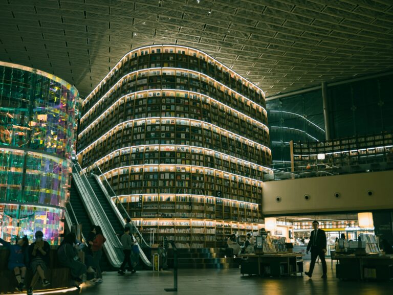 Public découvrant un festival de science-fiction dans une médiathèque de Cannes éclairée de lumières futuristes