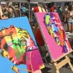 Chapiteau d'un salon d'art en bord de mer à Antibes avec visiteurs et œuvres exposées