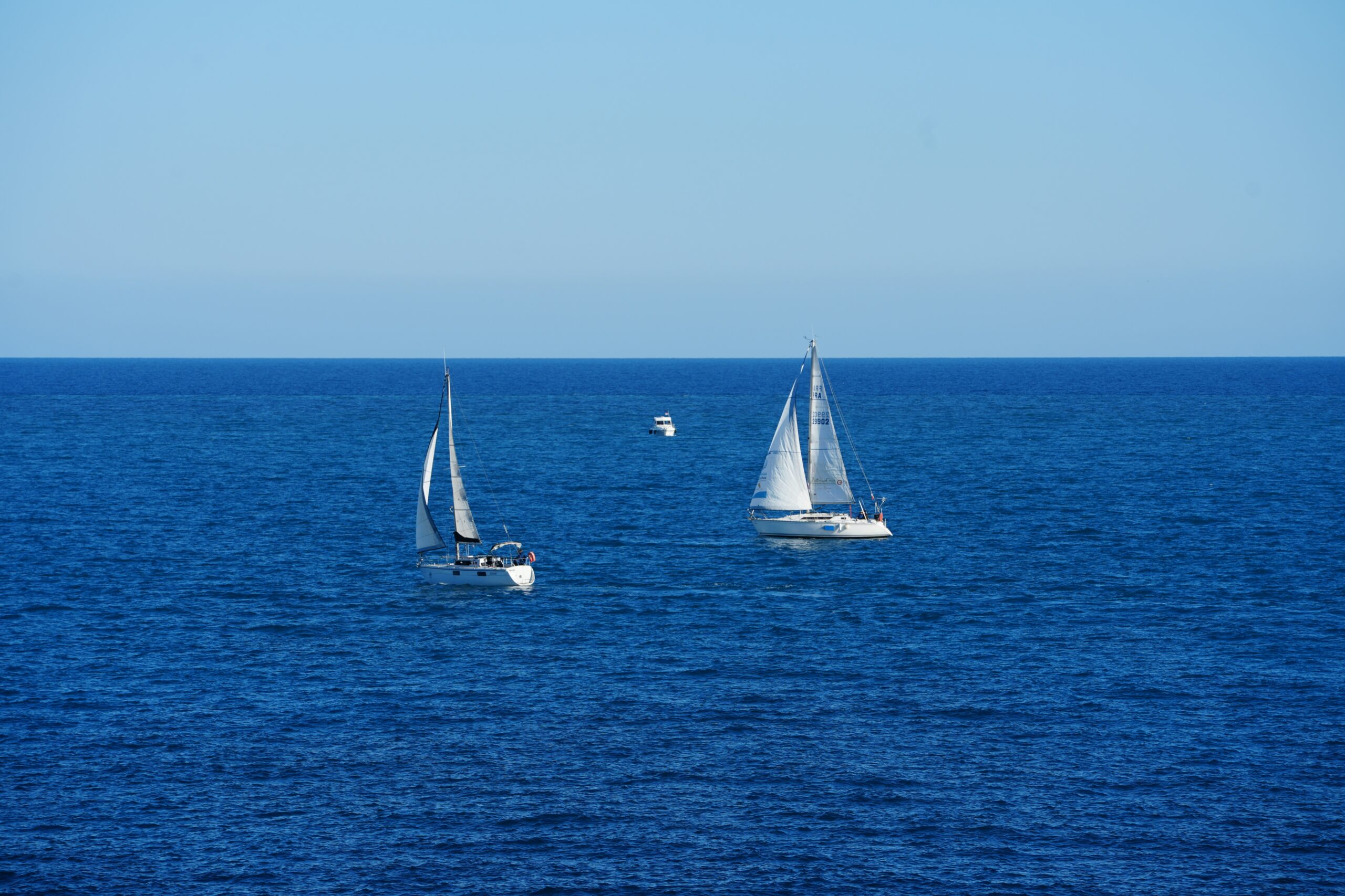 Voiliers en régate au large d'Antibes avec le Port Vauban en arrière‑plan