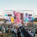 Foule sur la plage devant une scène de musique électronique à Cannes pendant un festival estival